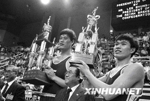 中国八一男子篮球队队员穆铁柱(左二)和匡鲁彬领取第一届世界男子篮球俱乐部冠军队锦标赛亚洲区选拔赛冠军队奖杯和纪念杯(1981年4月摄)。新华社发