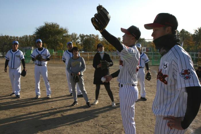 北京棒球队队员梁培和胡劲勇为队员进行技术指导，人民棒球供图 陈功 摄