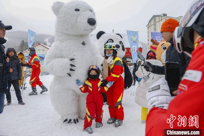 滑雪爱好者在开幕式现场与吉祥物合影。　吕品 摄