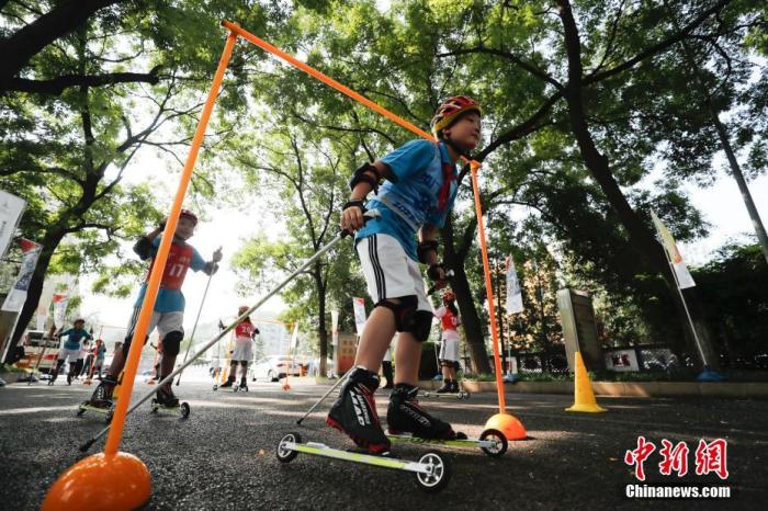 8月8日，北京广宁街道冬奥社区举办全民健身日活动，室外的趣味冰雪体验区举办的冰壶游戏，花样轮滑和特别设置的“夏季滑雪场”让辖区居民感受到了冰雪运动的乐趣。图为市民体验轮滑。
/p中新社记者 杜洋 摄