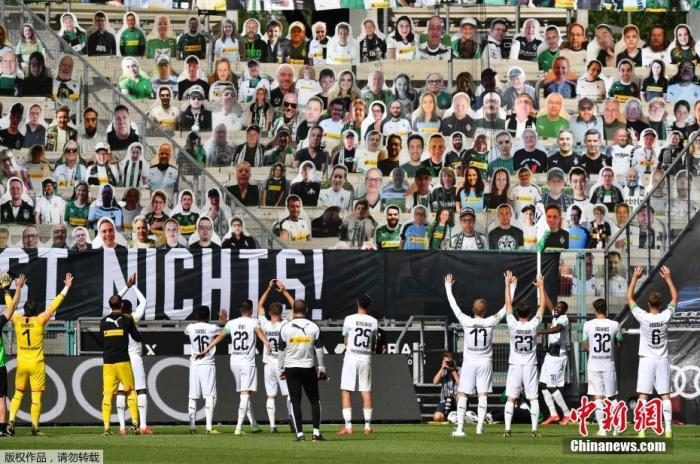 5月31日，德甲现场，球员们赛后面向观众席庆祝胜利，而看台上坐着的是纸板球迷，Martin Meissner 摄