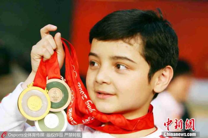 童星阿尔法展示奥运奖牌。图片来源：Osports全体育图片社