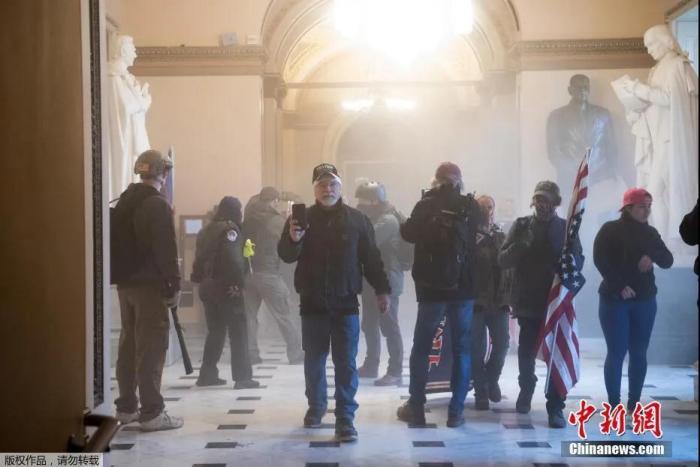 当地时间1月6日,美国参众两院确认选举人团投票结果的联席会议,因现任总统特朗普支持者闯入国会大厦引发大规模骚乱而被迫中断,现场极度混乱。图为特朗普支持者在国会大厦内抗议。 当地时间1月6日,美国参众两院确认选举人团投票结果的联席会议,因现任总统特朗普支持者闯入国会大厦引发大规模骚乱而被迫中断,现场极度混乱。图为特朗普支持者在国会大厦内抗议。
