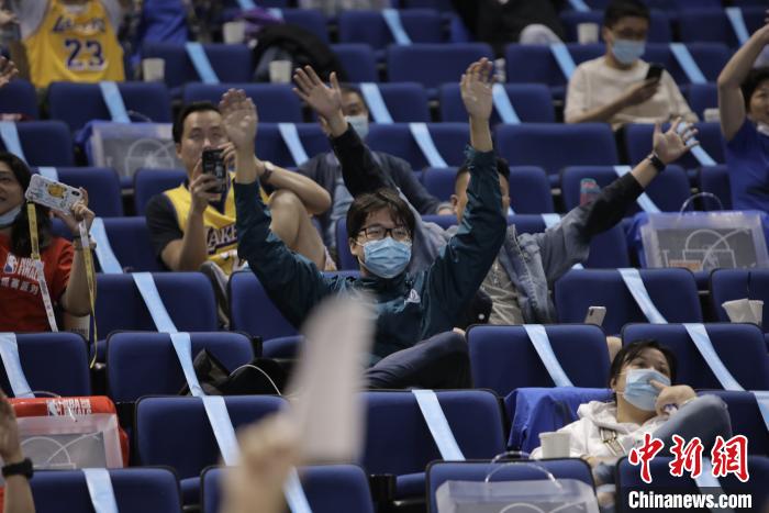 资料图：球迷现场为主队振臂庆祝，仍有人手握手机。NBA中国 摄