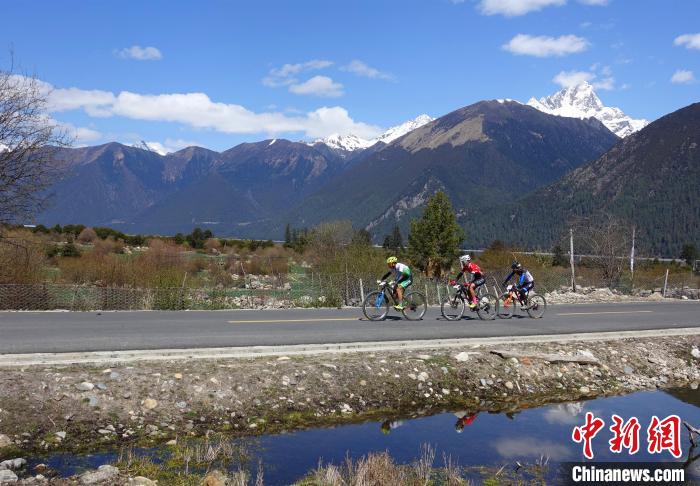 图为参赛选手在雪山下骑行。 冉文娟 摄 图为参赛选手在雪山下骑行。 冉文娟 摄