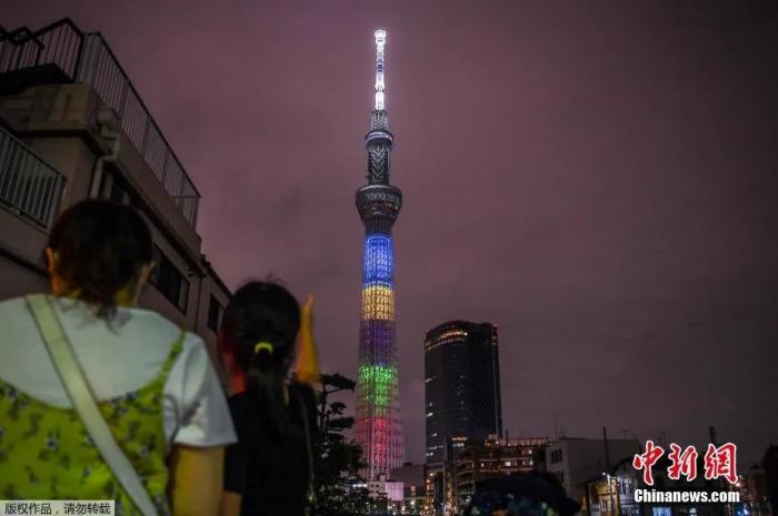 资料图：当地时间2020年7月23日，东京奥运会倒计时一周年，东京晴空塔亮起奥运五环色灯光。