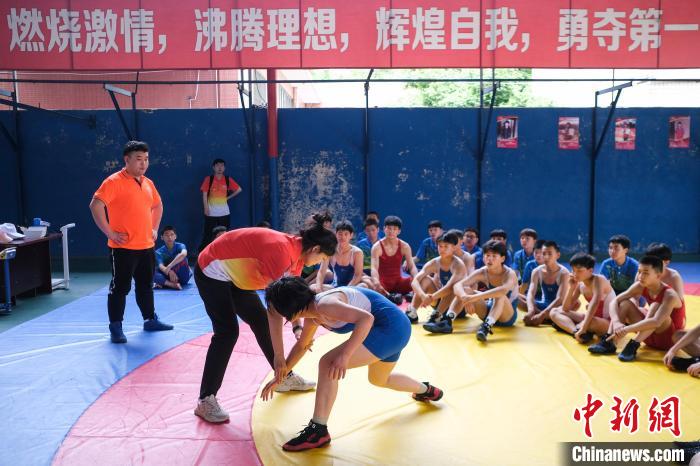 奥运会摔跤冠军王娇(前排左)为孩子们进行训练指导。　何蓬磊 摄
