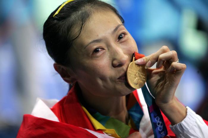 张宁在雅典奥运会女单比赛颁奖后含泪亲吻金牌。 /p中新社记者 任晨鸣 摄