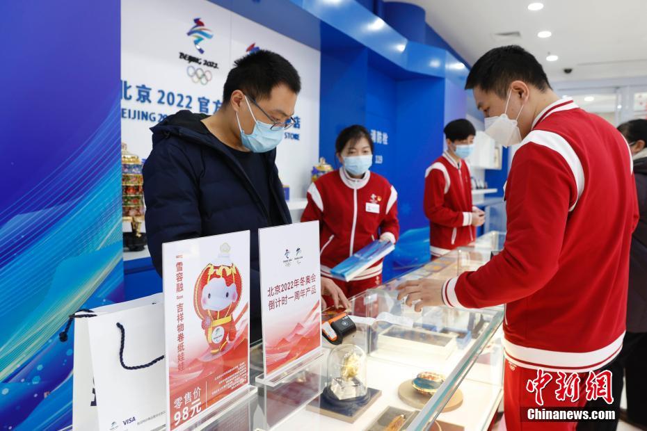 资料图：北京2022官方特许商品旗舰店内，工作人员在柜台前忙碌。/p中新社记者 韩海丹 摄