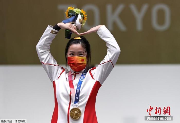 7月24日举行的东京奥运会女子10米气步枪决赛中，中国选手杨倩夺得冠军，为中国代表团揽入本届奥运会第一枚金牌。图为杨倩在领奖台上比出爱心手势。