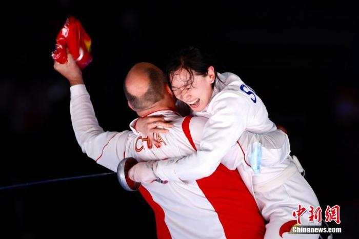 7月24日晚,东京奥运会女子重剑个人赛结束了决赛的较量,中国选手孙一文以11:10战胜罗马尼亚选手波佩斯库,夺得冠军。这是中国体育代表团在本届奥运会的第三枚金牌。图为孙一文夺冠后和团队成员一起庆祝。中新社记者 富田 摄 7月24日晚,东京奥运会女子重剑个人赛结束了决赛的较量,中国选手孙一文以11:10战胜罗马尼亚选手波佩斯库,夺得冠军。这是中国体育代表团在本届奥运会的第三枚金牌。图为孙一文夺冠后和团队成员一起庆祝。/p中新社记者 富田 摄