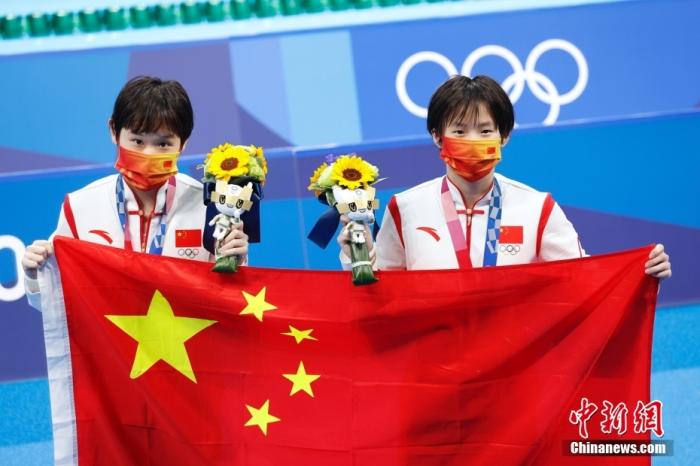 当地时间7月27日,初次亮相奥运赛场的中国跳水小将陈芋汐和张家齐顶住压力,以363.78分成功夺得东京奥运会女子双人10米跳台冠军。图为陈芋汐和张家齐在场地内展示中国国旗。中新社记者 韩海丹 摄 当地时间7月27日,初次亮相奥运赛场的中国跳水小将陈芋汐和张家齐顶住压力,以363.78分成功夺得东京奥运会女子双人10米跳台冠军。图为陈芋汐和张家齐在场地内展示中国国旗。/p中新社记者 韩海丹 摄