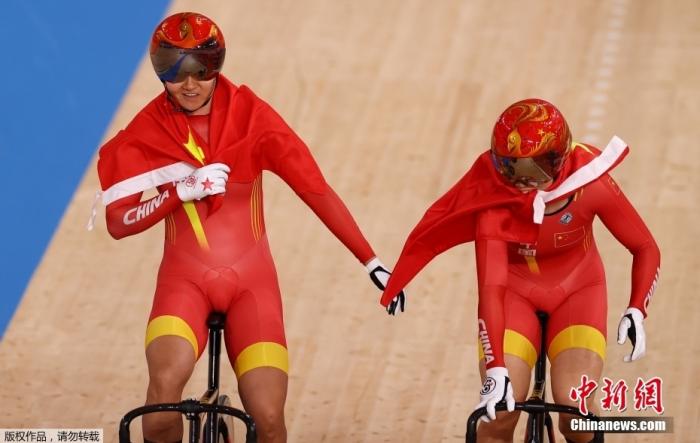东京奥运会场地自行车女子团体争先赛中，由钟天使和鲍珊菊组成的中国队以31秒895夺得冠军。图为钟天使(左)和鲍珊菊(右)庆祝胜利。