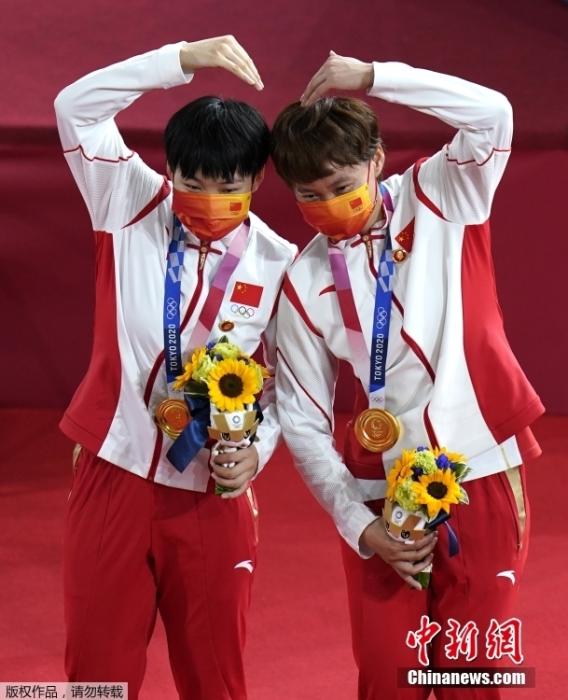 北京时间8月2日，在东京奥运会场地自行车女子团体争先赛中，由钟天使和鲍珊菊组成的中国队以31秒895夺得冠军。这是中国代表团的第28金。图为钟天使(右)和鲍珊菊(左)比心。