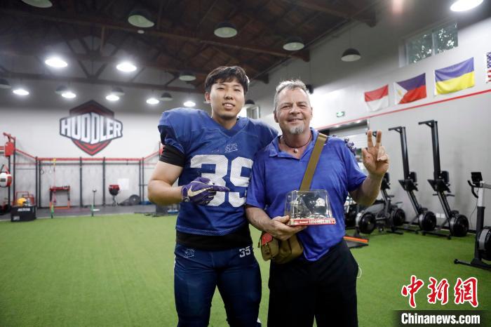 8月7日，北京野蛮人美式橄榄球队队员海云飞送美国教练Patrick离别礼物。　侨报特约记者李铎摄 摄